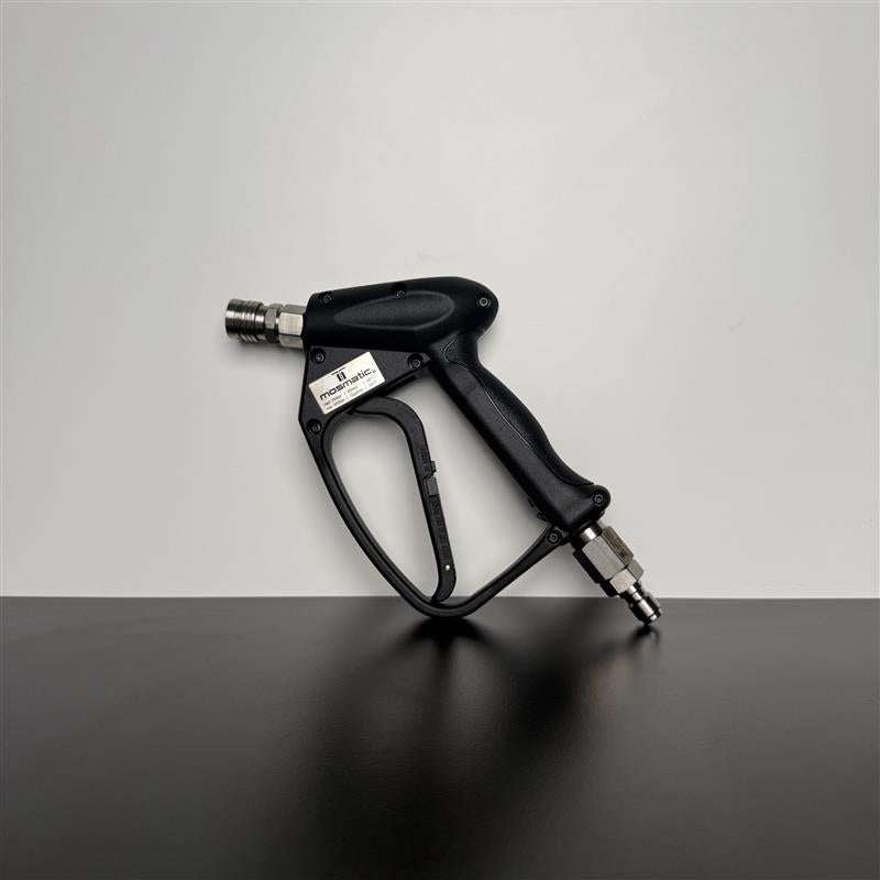 A black high-pressure water gun with silver metal fittings, resting on a dark reflective surface against a light gray background.
