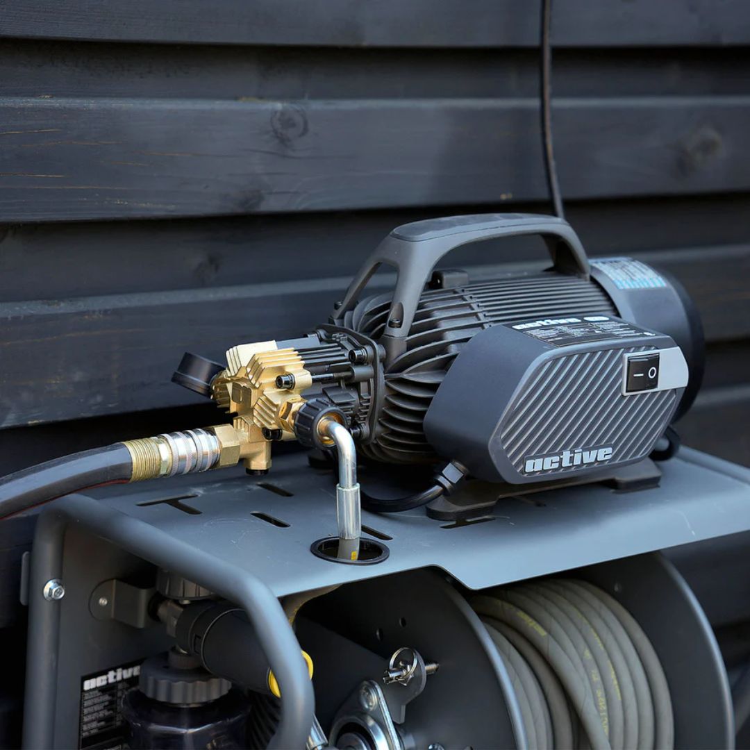Pressure washer with hose and nozzle against a wooden background